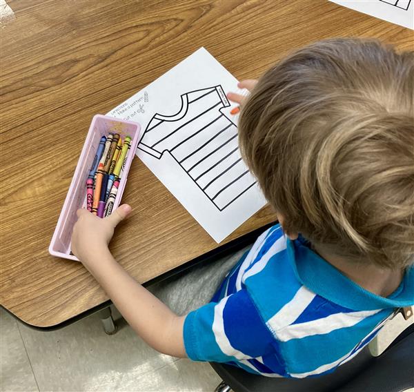 Student working on patterns by coloring a striped shirt