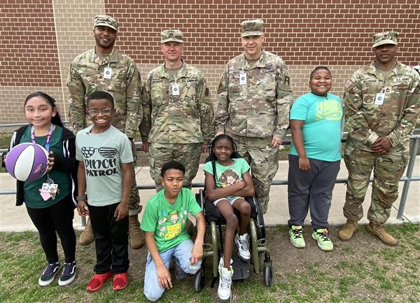 photo of Ft. Hood soldier volunteers with several students.