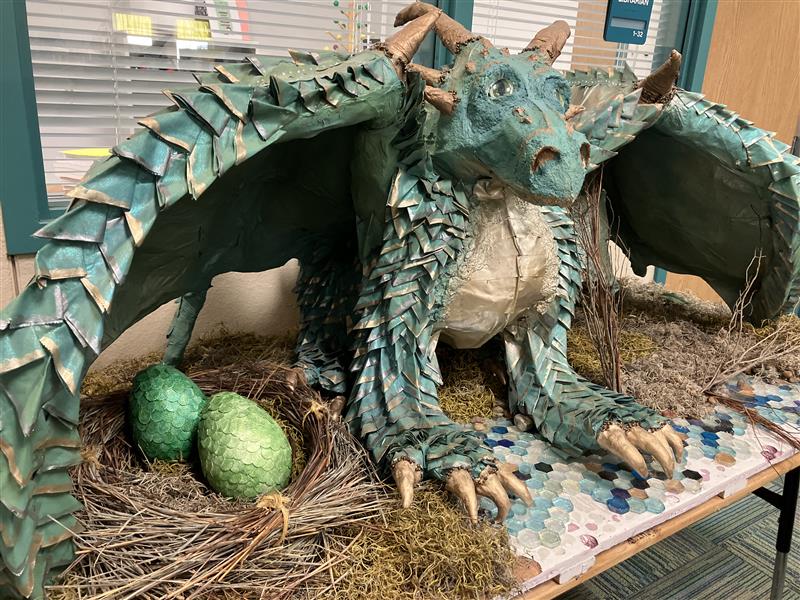 A green paper seiche dragon that is guarding her eggs and the Library