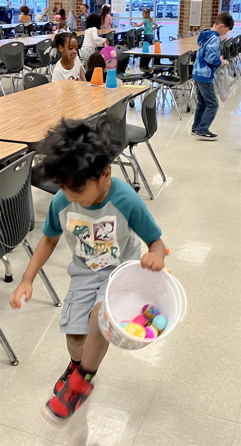 picture of a sole student kindergartener hunting eggs