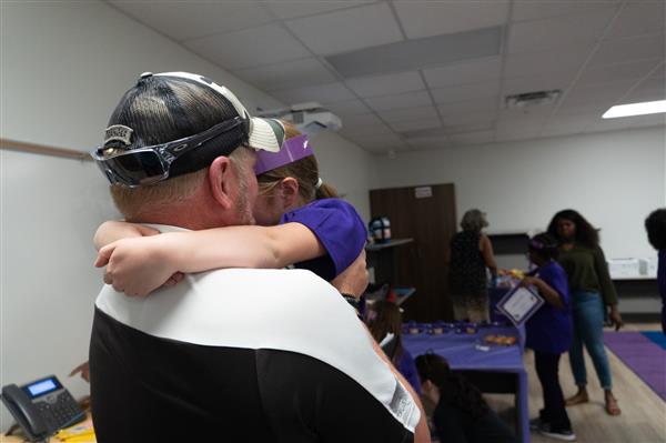 Daughter embraces Father